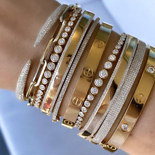 About: This pavé cuff bracelet features a sleek open silhouette with tapered ends lined in round diamonds. Crafted in 14K gold, it feels sculptural, polished, and quietly statement making.

Diamond Details: 340 Pavé Natural Diamonds

Total Carat Weight: 0.82 Carats
Color: G/H
Clarity: SI

Metal: 14K Solid Gold&nbsp;

Lengths: Available in 15, 16, 17, 18, and 19 cm

Closure: Hinge closing&nbsp;