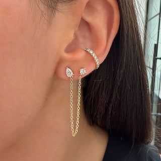 About: Pear shape and round lab diamond stud are connected by a delicate gold chain, creating effortless movement between two piercings. Modern and unexpected, this pair adds a refined edge to any ear stack.

Diamond Details: 2 Pear &amp; 2 Round Lab Diamonds

Total Carat Weight: 0.79 Carats
Color:&nbsp;E/F
Clarity: VS

Metal: 14K Gold

Chain Length: 3"

Closure:&nbsp;Push Back

Sold as a pair.